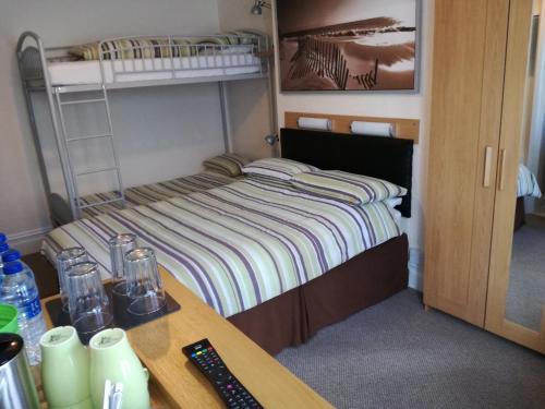 a small room with a bed and a desk with a desk at Driftwood B&B Weymouth in Weymouth