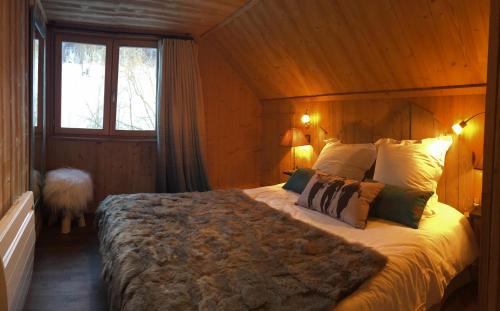 Un dormitorio con una cama grande en una habitación de madera. en Chalet Pegulu, en Puy-Saint-Vincent