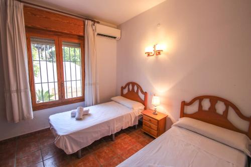 deux lits jumeaux dans une chambre avec fenêtre dans l'établissement Pedro - two story holiday home villa in El Portet, à Moraira