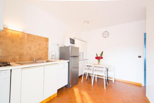 une cuisine avec des armoires blanches et un réfrigérateur en acier inoxydable dans l'établissement villa 