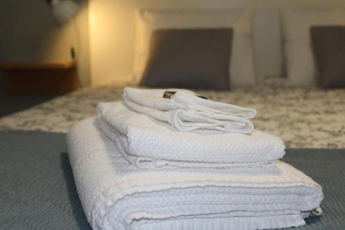 a pile of white towels sitting on top of a bed at Lost in Terceira in Angra do Heroísmo