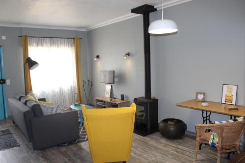 a living room with a table and a yellow chair at Lost in Terceira in Angra do Heroísmo