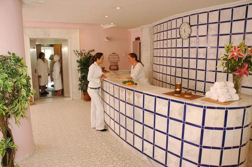 a man and woman standing at a counter in a salon at El Mouradi Hammamet in Hammamet