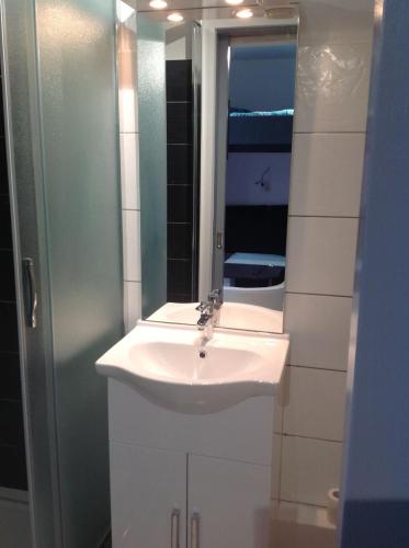 une salle de bain avec un lavabo blanc et un miroir dans l'établissement studio des écureuil, à Gérardmer