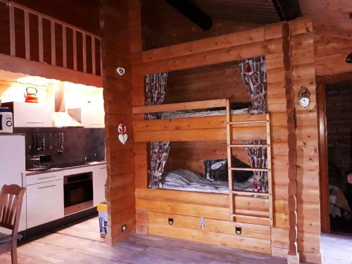 Ce chalet en bois dispose d'une cuisine avec des lits superposés. dans l'établissement Appartement Cosy, à Gérardmer