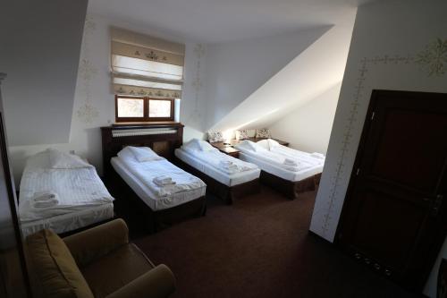 A bed or beds in a room at Hotel Marzanna