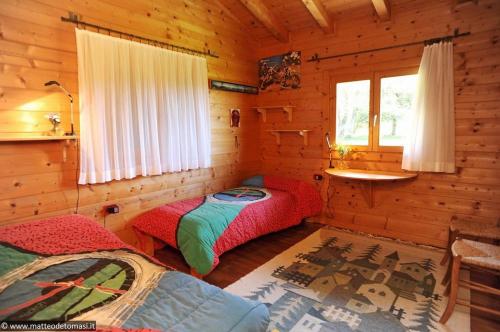 a bedroom with two beds in a log cabin at Villa Tirolese in Due Cossani