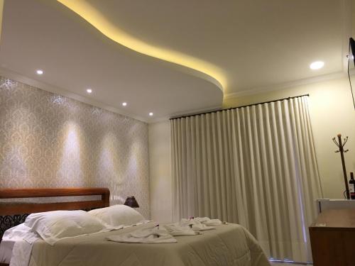 a bedroom with a bed with towels on it at Pousada Maria Monteiro Tiradentes in Tiradentes