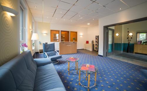 a living room with a couch and two tables at Berghotel Tambach in Tambach-Dietharz