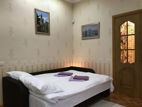 ein Schlafzimmer mit einem Bett mit lila Kissen darauf in der Unterkunft Large apartment in the city center in Mukatschewo