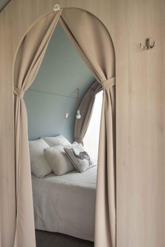 a bedroom with a canopy bed with a window at Camping Fontana delle Rose in Mattinata