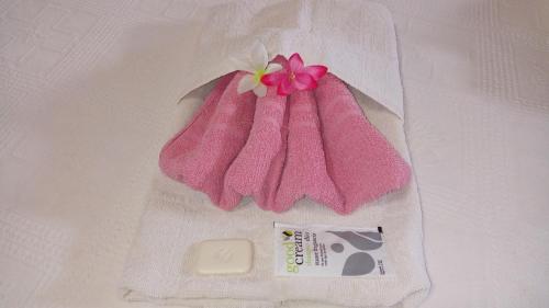 a pink towel with a flower on top of it at Hotel Ideal in Montecarlo