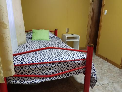 a bed with a red frame in a room at Hostal Aventura Austral in Punta Arenas
