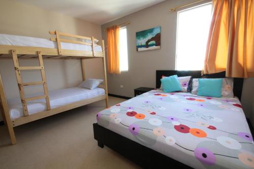a bedroom with two bunk beds and a bed with flowers at Fogata Hostel in Salinas
