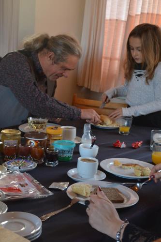 a group of people sitting around a table eating food at Guesthouse Kolibriehuys in Nieuwkerke