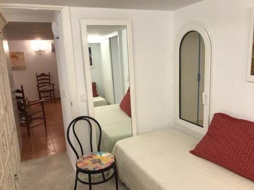 サン・エルムにあるHébergement front de merのベッドルーム1室(ベッド1台、椅子、鏡付)