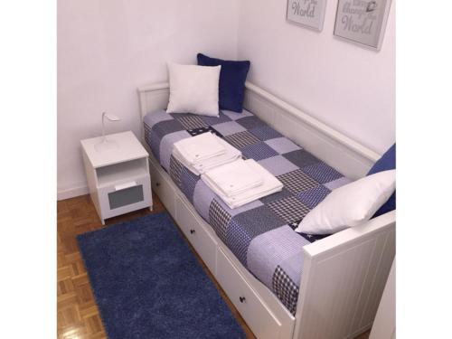 a small bedroom with a bed with a blue rug at Parque del Carmen in Logroño