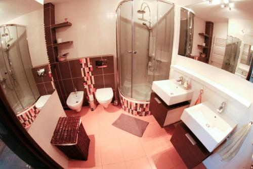 サンドミエシュにあるApartament Sandomierskie Wzgórzeのバスルーム(シンク2台、シャワー、トイレ2つ付)