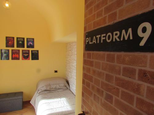 una habitación con una pared de ladrillo y un cartel en la pared en Al Nove e TreQuarti, en Salerno