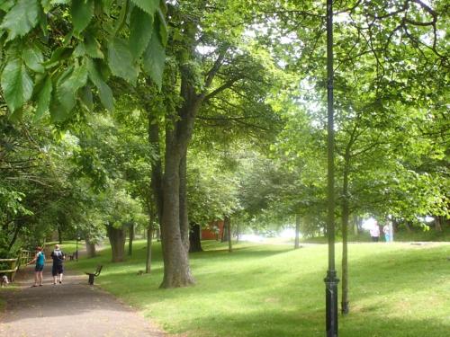 two people walking down a path in a park at Driftwood B&B Weymouth in Weymouth