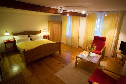 a bedroom with a wooden bed and a red chair at Beate's Bed & Breakfast in Münzenberg