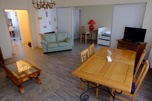 a living room with a table and a couch at Mei Hôtel-Restaurant in Sarrebourg