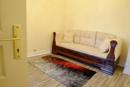 a couch sitting in a corner of a room at Mei Hôtel-Restaurant in Sarrebourg