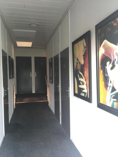 a hallway with paintings on the walls of a building at De Twentse Nar in De Lutte