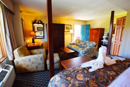 a hotel room with a bed and a living room at Arbors at Island Landing Hotel & Suites in Pigeon Forge