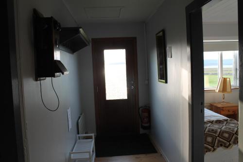 a hallway with a door leading to a bedroom at Midhop guesthouse in Þingeyrar