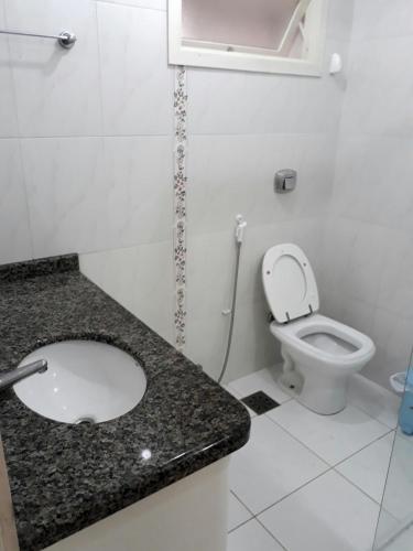 a bathroom with a sink and a toilet at Edifício Torre de Prata in Torres