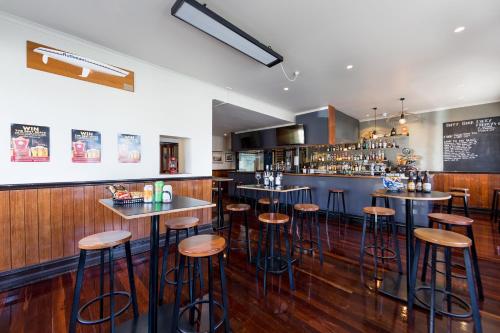 a bar with bar stools in a restaurant at Customs House Hotel in Hobart