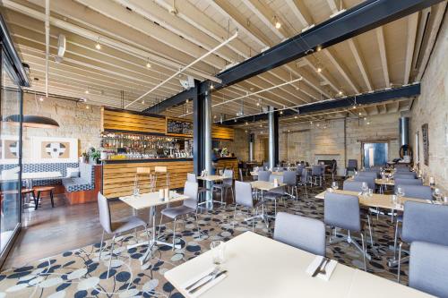 a restaurant with tables and chairs and a bar at Customs House Hotel in Hobart