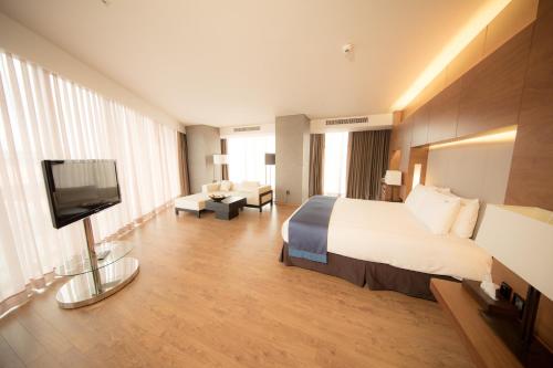 a hotel room with a bed and a flat screen tv at Holiday Inn Gwangju, an IHG Hotel in Gwangju