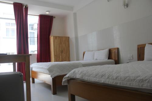 a hotel room with two beds and a window at Sai Gon River Hotel in Ho Chi Minh City