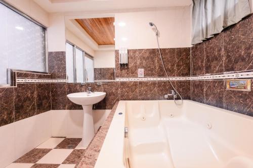 a bathroom with a white tub and a sink at Guest Motel- Zhongli Branch in Pingzhen