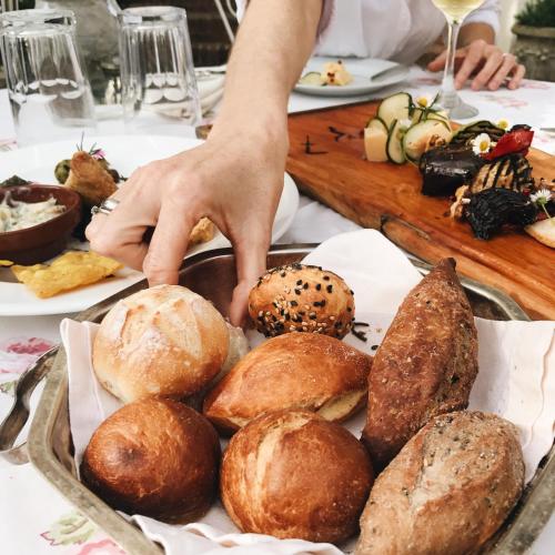 a person reaching for a tray of bread at Alquimista Montevideo in Montevideo