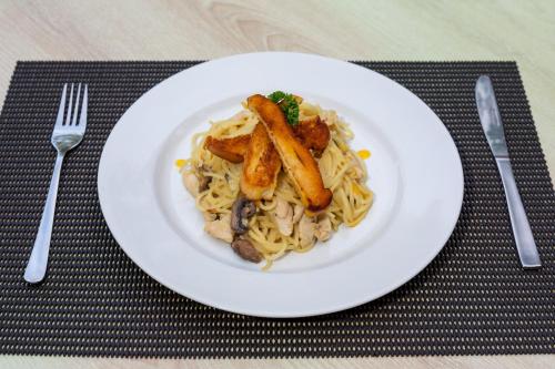 een wit bord met pasta en champignons bij The Rinaya Canggu by ecommerceloka in Canggu