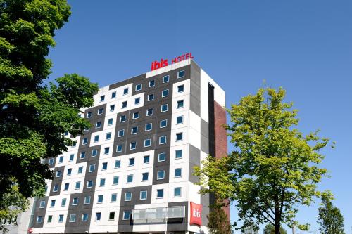 a white building with a sign on the top of it at ibis Amsterdam City West in Amsterdam