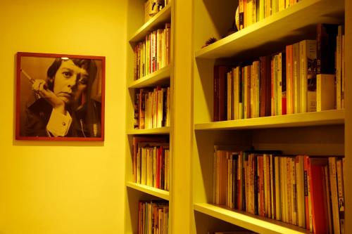 a book shelf filled with books with a picture of a man at Hangzhou JiuYueJi Bed&Breakfast in Hangzhou