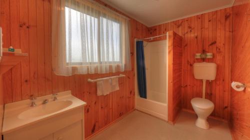 uma casa de banho com um lavatório branco e um WC. em Low Head Tourist Park em Low Head