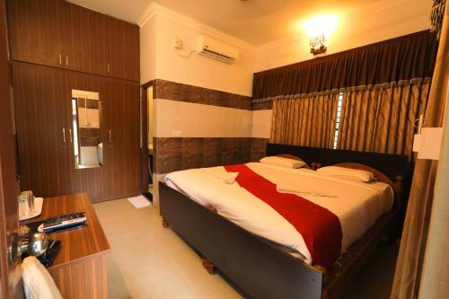 a bedroom with a bed and a desk in it at Jal Mahal Resort and Spa in Mysore