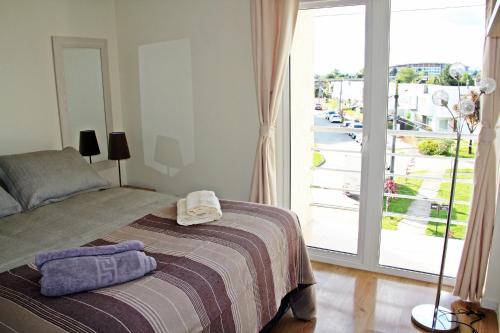 1 dormitorio con 1 cama y puerta corredera de cristal en Departamento Arrieros, en Osorno