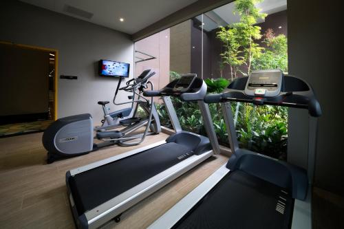 a gym with two exercise bikes and a television at Hotel Mi in Singapore