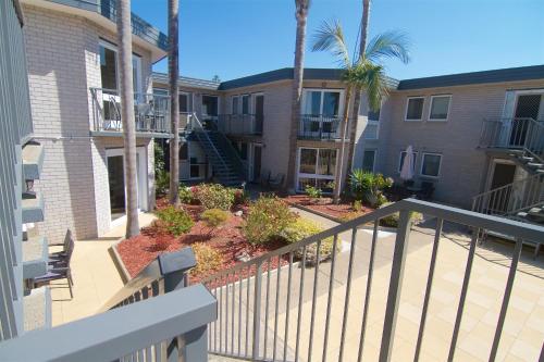 a balcony of a apartment building with palm trees at The Sands Holiday Apartments in Merimbula