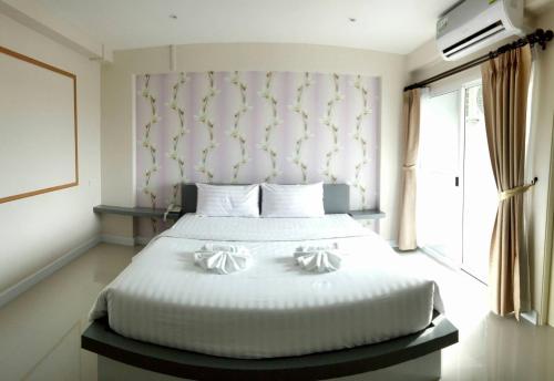 a bedroom with a bed with two pillows on it at Nava Grand in Ban Talat Rangsit