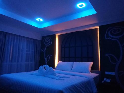 a bedroom with two beds with blue lights on it at Nava Grand in Ban Talat Rangsit