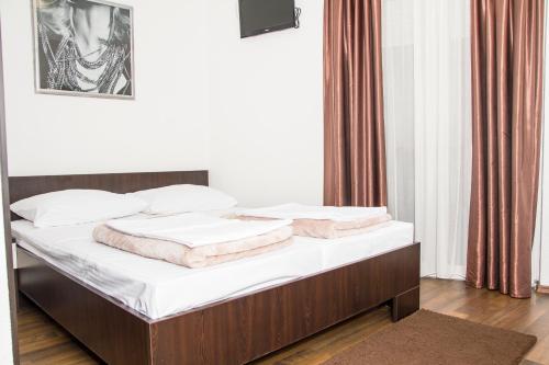 a bed with two pillows on it in a room at Hotel Storia in Čapljina