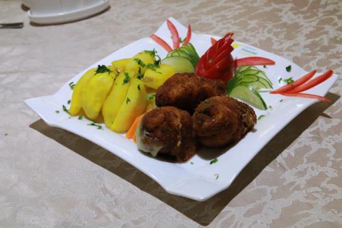 a plate of food with fruit on a table at Tiffany Diamond Hotels Ltd - Indira Gandhi street in Dar es Salaam