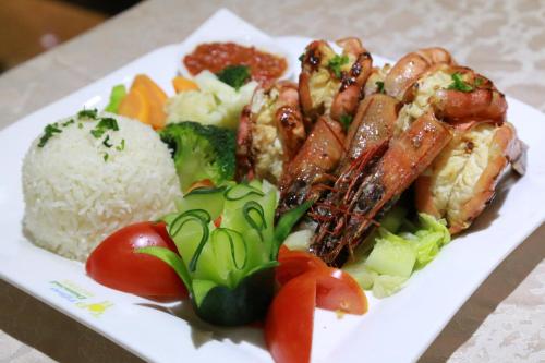 a plate of food with rice and meat and vegetables at Tiffany Diamond Hotels Ltd - Indira Gandhi street in Dar es Salaam